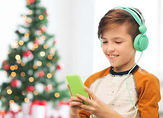 Image showing boy with smartphone and headphones at christmas