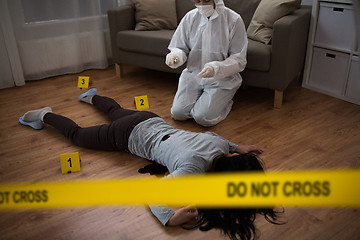 Image showing criminalist collecting evidence at crime scene