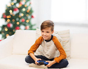 Image showing boy with gamepad playing video game at christmas