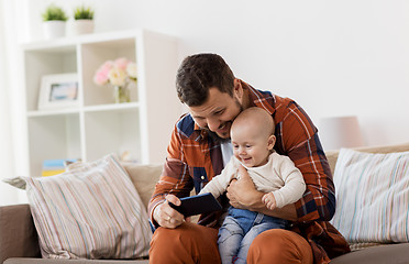 Image showing father and baby boy with smartphone at home