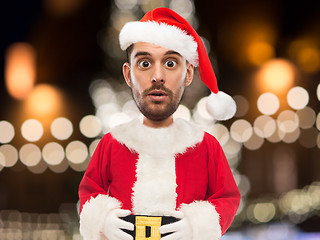 Image showing man in santa claus costume over christmas lights