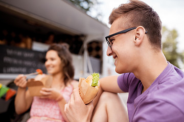 Image showing happy man eating hamburger at food truck