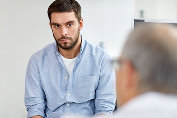 Image showing young male patient talking to doctor at hospital