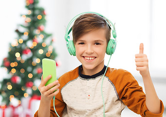 Image showing boy with smartphone and headphones at christmas