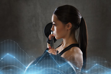 Image showing young woman flexing muscles with barbell in gym