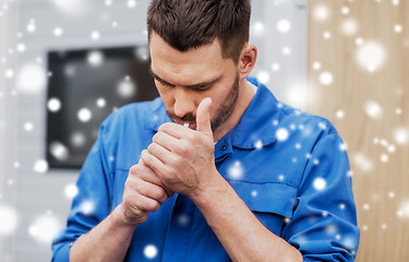 Image showing auto mechanic lighting up or smoking cigarette