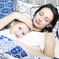 Image showing Portrait of mother and daughter laying in bed and smiling, lifestyle people concept