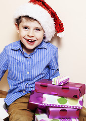 Image showing little cute boy with Christmas gifts at home. close up emotional