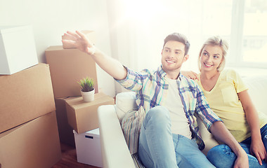 Image showing couple with boxes moving to new home and dreaming