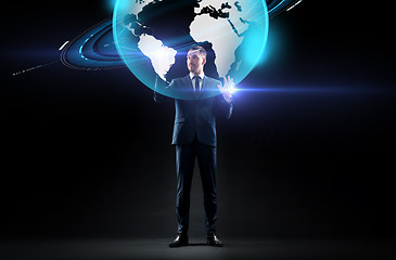 Image showing businessman with earth hologram over black