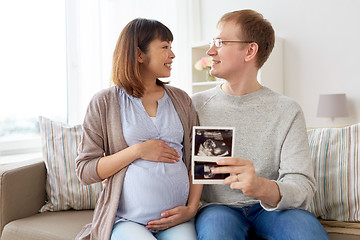 Image showing happy couple with ultrasound images at home