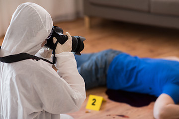 Image showing criminalist photographing dead body at crime scene