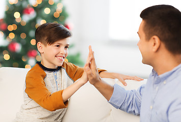 Image showing happy father and son doing high five at christmas