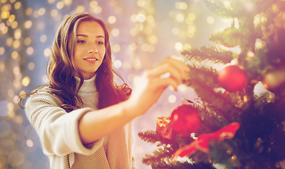 Image showing happy young woman decorating christmas tree