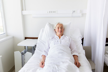 Image showing smiling senior woman lying on bed at hospital ward