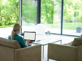 Image showing Young woman using laptop at home