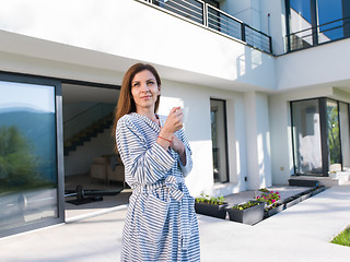 Image showing woman in a bathrobe enjoying morning coffee