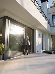 Image showing woman drinking coffee in front of her luxury home villa