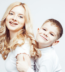 Image showing young modern blond curly mother with cute son together happy smiling family posing cheerful on white background, lifestyle people concept, sister and brother friends