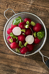 Image showing Several red radishes in a sieve