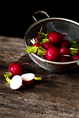 Image showing Several red radishes in a sieve