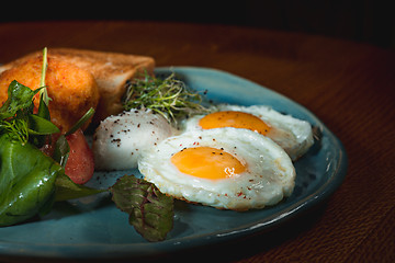 Image showing Scrambled eggs on meat with fried potatoes and toast