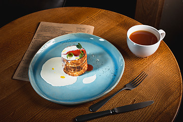 Image showing plate with tasty pancakes on wooden table