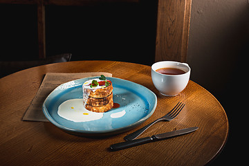 Image showing plate with tasty pancakes on wooden table