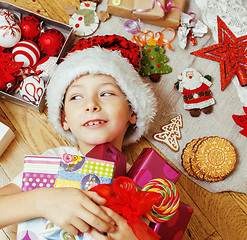 Image showing little cute boy with Christmas gifts at home. close up emotional happy smiling in mess with toys, lifestyle holiday people concept