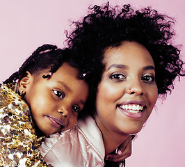 Image showing young pretty african-american mother with little cute daughter hugging, happy smiling on pink background, lifestyle modern people concept 