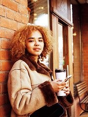Image showing young pretty african american women drinking coffee outside in c