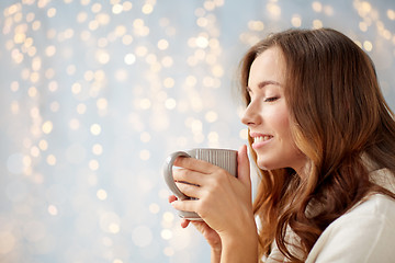 Image showing happy woman with cup of tea or coffee at home