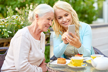 Image showing daughter and senior mother with smartphone at cafe