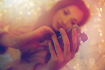 Image showing close up of woman with smartphone in bed at home