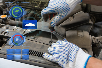 Image showing mechanic man with wrench repairing car at workshop