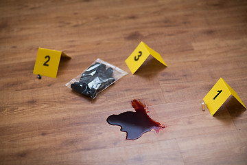 Image showing knife in blood and evidence marker at crime scene