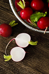 Image showing Several red radishes on a wooden board.