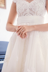 Image showing bride’s hand with wedding ring on dress