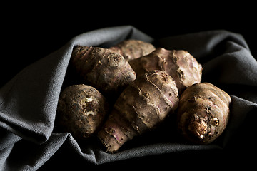 Image showing Several Jerusalem artichokes on a gray cotton napkin.