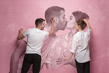 Image showing The collage about couple writing something on a pink wall