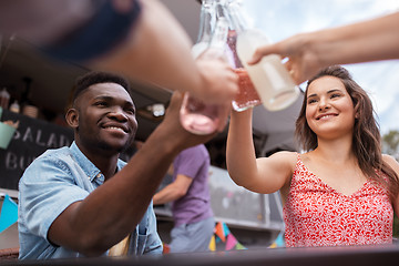 Image showing friends clinking bottles with drinks at food truck