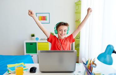 Image showing boy with headphones playing video game on laptop