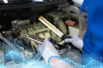 Image showing mechanic man with pliers repairing car at workshop