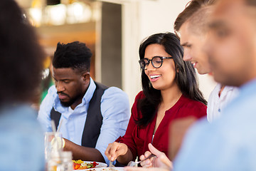 Image showing happy friends eating at restaurant