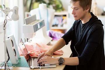 Image showing fashion designer with laptop working at studio