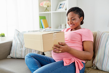 Image showing happy pregnant woman with parcel box at home