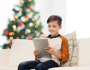 Image showing smiling boy with tablet pc at home at christmas