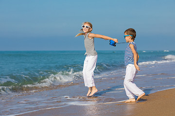 Image showing Two happy children playing on the beach at the day time