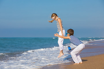 Image showing Two happy children playing on the beach at the day time