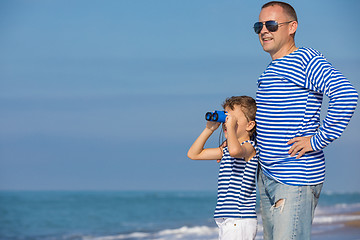 Image showing Father and son playing on the beach at the day time. Concept of 